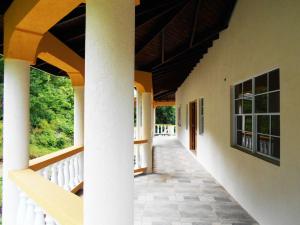 a hallway of a house with a porch and columns at VJ's Guesthouse Mountain View in Café