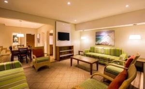 ein Wohnzimmer mit grünen Möbeln und ein Esszimmer in der Unterkunft Cabana Beach Resort in Durban