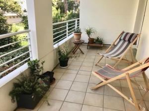 d'un balcon avec deux chaises et des plantes en pot dans l'établissement Le Bouscat: un superbe appartement en résidence, à Le Bouscat