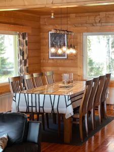 uma sala de jantar com uma mesa de madeira e cadeiras em Villa Kuusiranta em Ahtari
