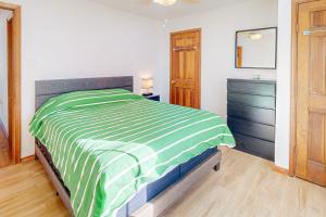 Un dormitorio con una cama verde y blanca y un tocador en Frazier Circle, Unit 2, en Oak Bluffs
