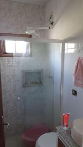 a bathroom with a shower and a toilet and a sink at CASA DE VERANEIO COM PISCINA in São Francisco do Sul