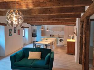 ein Wohnzimmer mit einem grünen Sofa und einem Tisch in der Unterkunft Entre Vignes et vergers Gite Parenthese in Gueberschwihr