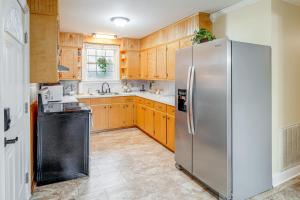 uma cozinha com um frigorífico de aço inoxidável e armários de madeira em Charming Milton Home with Porch - 5 Mi to VIR! em Milton