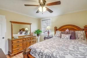 um quarto com uma cama, uma ventoinha de tecto e uma cómoda em Charming Milton Home with Porch - 5 Mi to VIR! em Milton