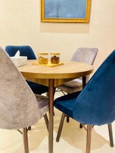 una mesa de madera con cuatro sillas azules alrededor en Stay In Marrakech Blue Appartment en Marrakech