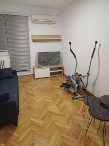 een woonkamer met een tafel en een hometrainer bij Stan na dan Beograd-Banjica in Kanarevo Brdo