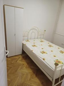 een bed in een kamer met 2 witte stoelen bij Stan na dan Beograd-Banjica in Kanarevo Brdo