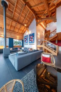 una sala de estar con un sofá y una mesa en Chalet Snowbird 5 étoiles, Serre-Chevalier, en La Salle-les-Alpes