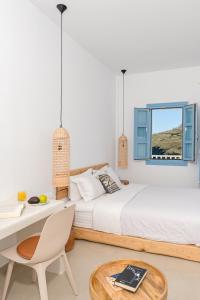 a bedroom with a bed and a desk and a table at Ihthioessa Boutique Hotel in Astypalaia