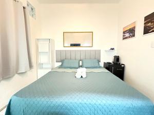 - une chambre avec un lit bleu et 2 serviettes dans l'établissement Studio'S Bartho Leblon, à Rio de Janeiro