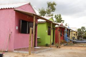 a row of houses are painted in different colors at Pousada Sitio do Terrão a 500 metros da BR 040 e a 10 minutos da Prainha in Três Marias