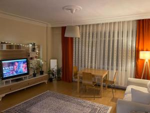 a living room with a couch and a table with a television at Üsküdar merkezde ve Kadıköy’e 5 dk uzaklıkta ev in Istanbul