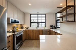 a kitchen with wooden cabinets and a white counter top at Tremblant Prestige - Les Eaux 215-8 in Mont-Tremblant