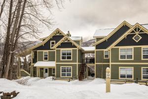 a green house with a black roof in the snow at Tremblant Prestige - Les Eaux 215-8 in Mont-Tremblant