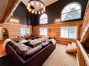 een grote woonkamer met een leren bank en ramen bij Glacier Dream Escape in Coram +95 foto's