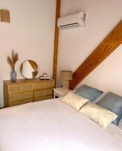 Schlafzimmer mit einem weißen Bett und einem Spiegel in der Unterkunft Duplex El Acebuche in Arroyo Frio