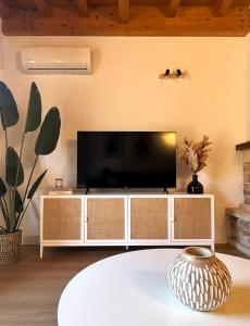 een woonkamer met een televisie op een witte kast bij Duplex El Acebuche in Arroyo Frio