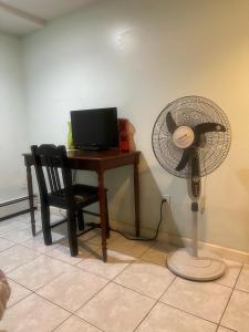 escritorio con ventilador junto a una mesa con ordenador en 24511 149th Road Rosedale, en Rosedale