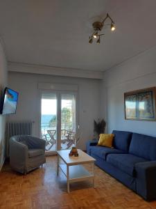 sala de estar con sofá azul y mesa en Nicola's House - Palio, en Kavala
