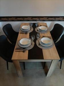 una mesa de madera con platos y copas de vino. en CASA PEPA en Guadalest