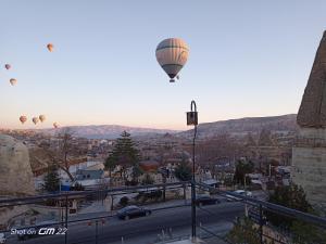 a group of hot air balloons flying over a city at Turan Cappadocia Cave in Goreme
