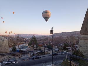 eine Gruppe von Heißluftballons, die über eine Stadt fliegen in der Unterkunft Turan Cappadocia Cave in Goreme