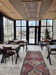 a dining room with tables and chairs and windows at Turan Cappadocia Cave in Goreme
