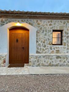 - un bâtiment avec une porte en bois et une fenêtre dans l'établissement Mas de Melonet Delta del Ebro, à L'Aldea