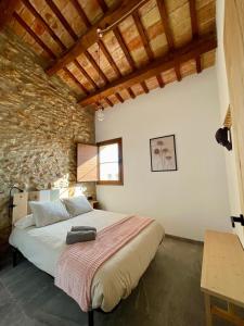 een slaapkamer met een groot bed in een stenen muur bij Mas de Melonet Delta del Ebro in L'Aldea