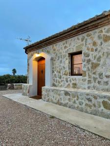 a stone building with a door and a window at Mas de Melonet Delta del Ebro in L'Aldea +37 photos