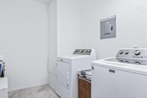 a white laundry room with a washer and dryer at SoCo Oasis Retreat: Relax in Comfort and Style in Austin