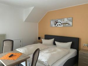 a bedroom with a bed and a table with a tableablish at Gasthof Rhönlust in Bischofsheim an der Rhön