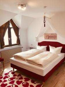 een slaapkamer met een groot bed met een rood hoofdeinde bij Gasthof Rhönlust in Bischofsheim an der Rhön