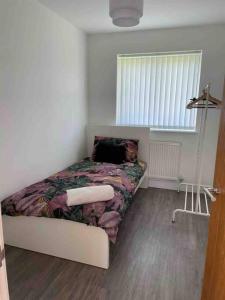 een slaapkamer met een bed in een kamer met een raam bij Stylish & modern, Private 2 bedroom apartment in Bristol