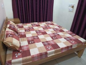 a bed with a quilt on it in a room at Anant Paying Guest house in Ayodhya