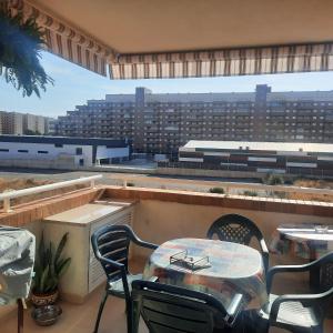 einen Tisch und Stühle auf einem Balkon mit Blick auf ein Gebäude in der Unterkunft Apartamento Magic World Oropesa in Oropesa del Mar