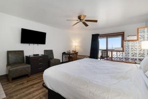 a bedroom with a bed and a flat screen tv at Snyders Shoreline Inn in Ludington