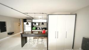 a kitchen with a counter and a white refrigerator at 105 Saint Sebastian Flat in Jaraguá do Sul