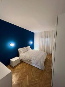 1 dormitorio con cama y pared azul en Milan Apartment - Città Studi: 75mq for you en Milán