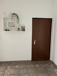 una puerta marrón en una pared blanca con un estante en Milan Apartment - Città Studi: 75mq for you en Milán