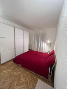 a bedroom with a red bed in a white room at Milan Apartment - Città Studi: 75mq for you in Milan