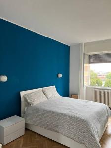 a blue bedroom with a bed and a blue wall at Milan Apartment - Città Studi: 75mq for you in Milan