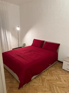 ein rotes Bett mit roten Kissen im Schlafzimmer in der Unterkunft Milan Apartment - Città Studi: 75mq for you in Mailand