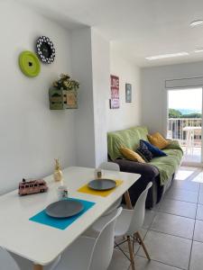 a living room with a table and a couch at Apartamento frente al mar con piscina in Malgrat de Mar