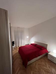 a bedroom with a red bed in a white room at Milan Apartment - Città Studi: 75mq for you in Milan