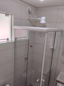a bathroom with a shower with a glass door at HORTA DO TOMATE in Bombinhas