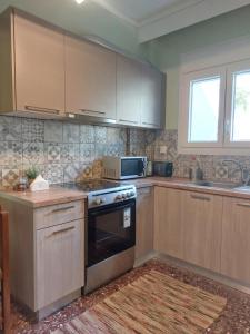 uma cozinha com armários de madeira e um forno com placa de fogão em Nicola's House - Palio em Kavala