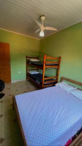 um quarto com uma cama e uma ventoinha de tecto em Paúba House em São Sebastião
