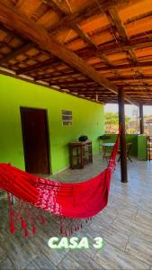 a red hammock in a room with a green wall at Paúba House in São Sebastião